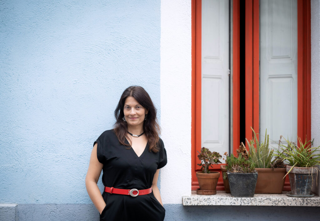 Porträt der rumänischstämmigen Dichterin Corina Oproae aus Katalonien vor rotem Fenster